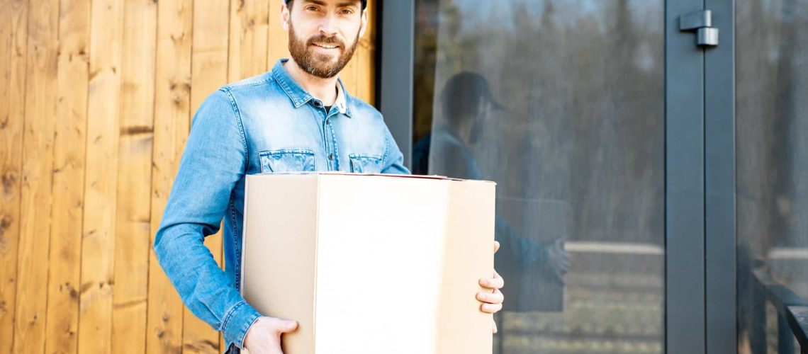 Delivery man with package near the house