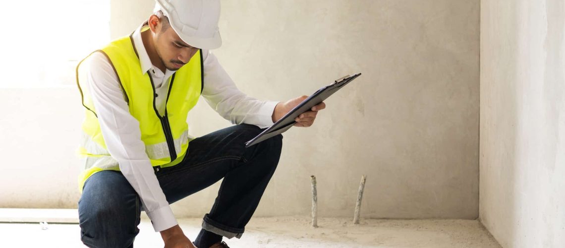 Inspector holding clipboard opening paper and checking building for renovation, Home inspection