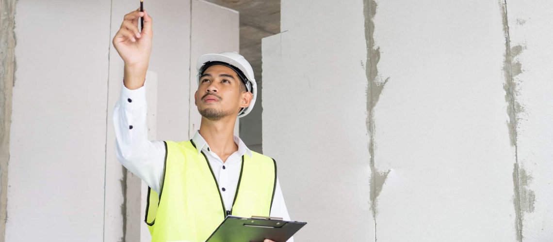Inspector holding clipboard opening paper and checking building for renovation, Home inspection